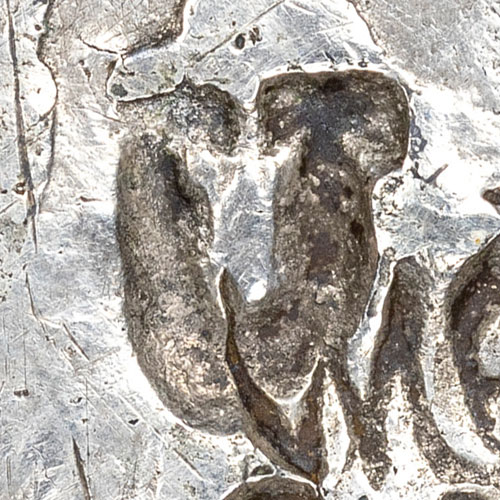 U - Latin-letter chopmark - A single Latin letter used as a chopmark. On foreign trade coins a Latin initial is most often the private mark of a Western merchant, assayer, or trading house that handled the coin, recording who tested or accepted it much as a Chinese shroff's name-stamp did. The specific person or business behind an individual letter is generally not identifiable, and the same letter could belong to different marks in different ports.